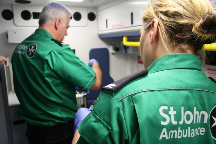 Photograph depicting two St John Ambulance volunteers at work on board a first aid vehicle