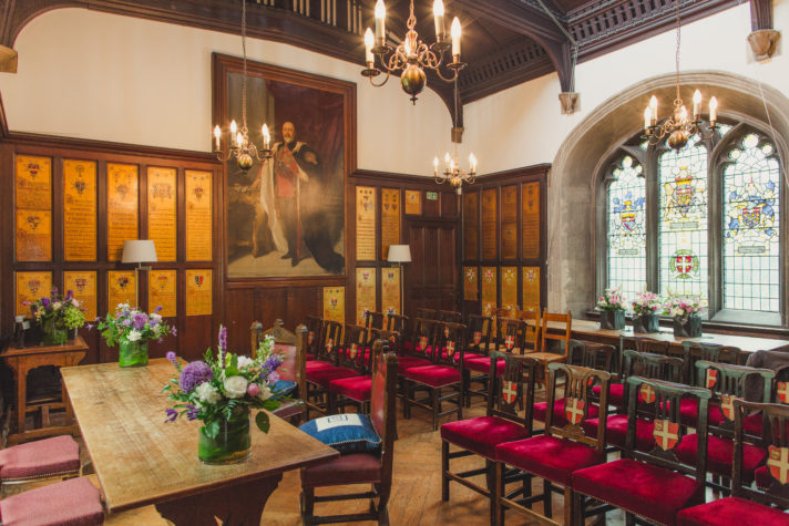 ALT="Council Chamber set up for small wedding with purple and white floral decorations"