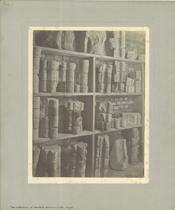 a black and white photograph of fragments on stone displayed on shelves