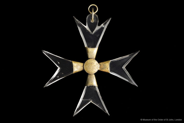 ALT="A photograph of an eight-pointed Maltese cross with rock crystal arms and a gilt bronze centre"