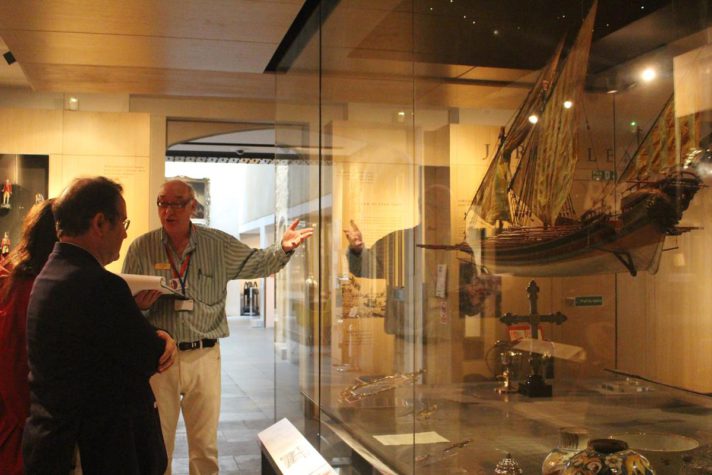 A museum guide showing visitors the gallery displays