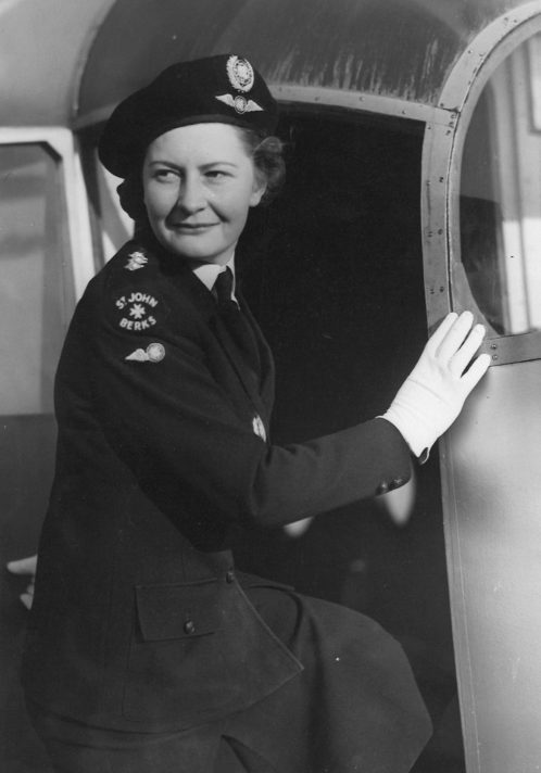 Black and white photograph of Susie George in uniform looking back whilst stepping into an aeroplane