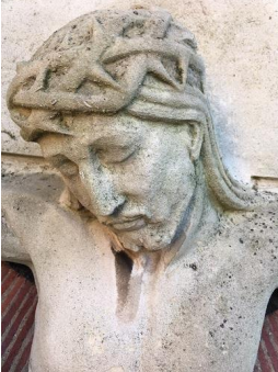 The Crucifixion statue detail showing organic growth staining