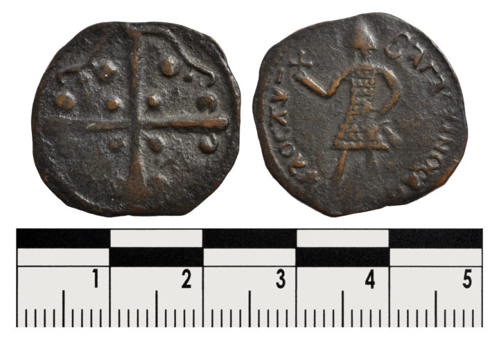 Two sides of a copper coin. One side with a cross, with decorative pellets. On the other wise a night in mail with a helmet holding a cross aloft and a sword lowered, with a Greek legend surrounding.