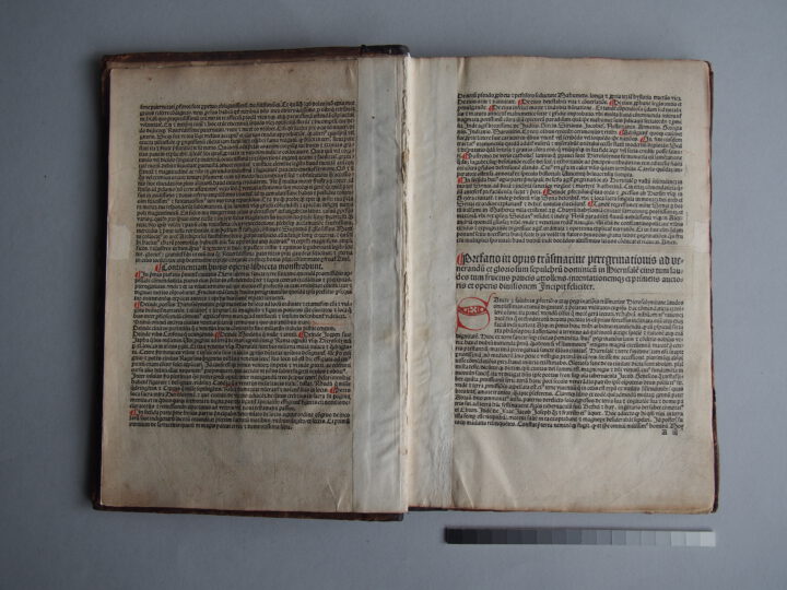 Photograph of a big open book showing a double-page spread of dense Latin text.