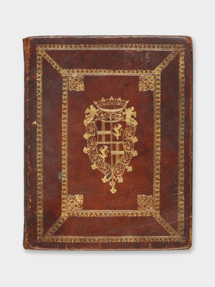 The front cover of a book bound in red leather with a coat of arms in gold in the centre.