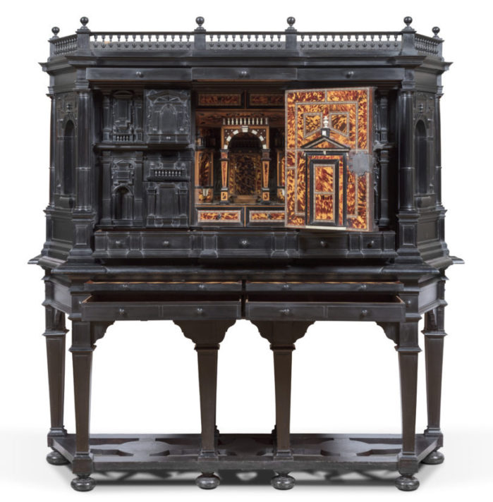 ALT="tall black cabinet on six joined legs, the central panel is open revealing an intricately designed false room"