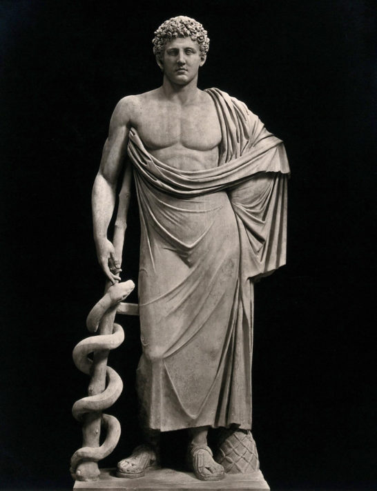 ALT="image of a statue of a man in robes leaning on a staff with a sepent coiled around it"