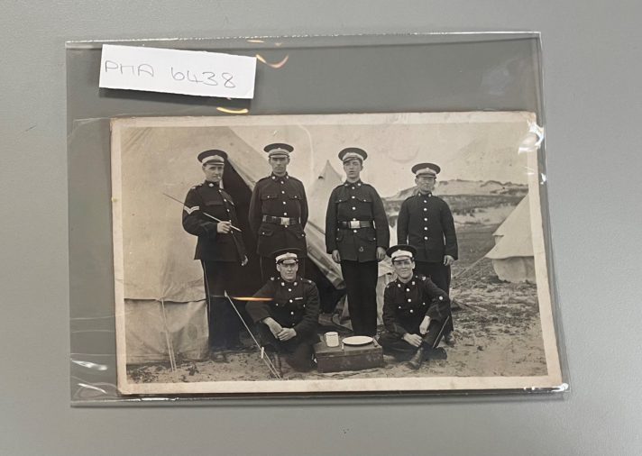 This image shows a black and white photograph housed in an archival standard polyester photographic wallet, labelled in pencil with the photograph's catalogue reference number.