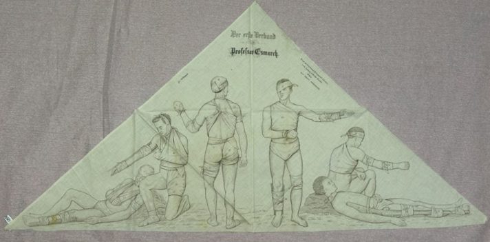 [Image of: light yellow calico triangular bandage with German text at top, illustrations of six male figures wearing bandages on different parts of their body] 