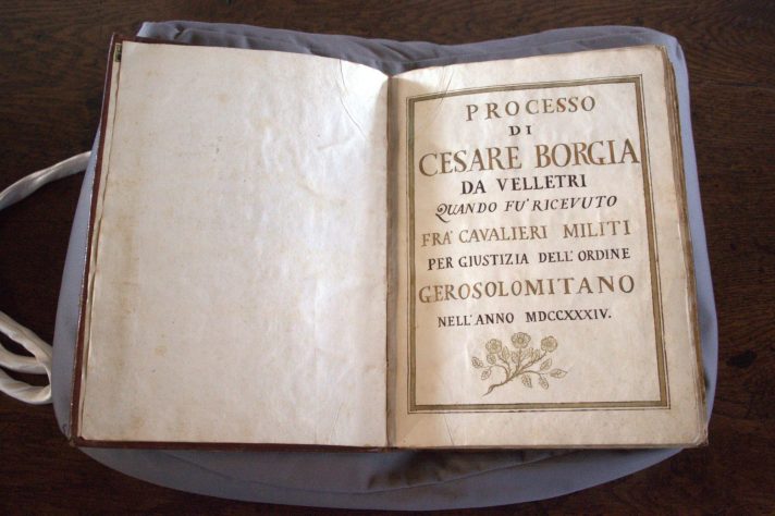 The book of Borgia’s ‘Proofs’ is open to its first page, displaying the gilded title and the date written in Roman numbers.